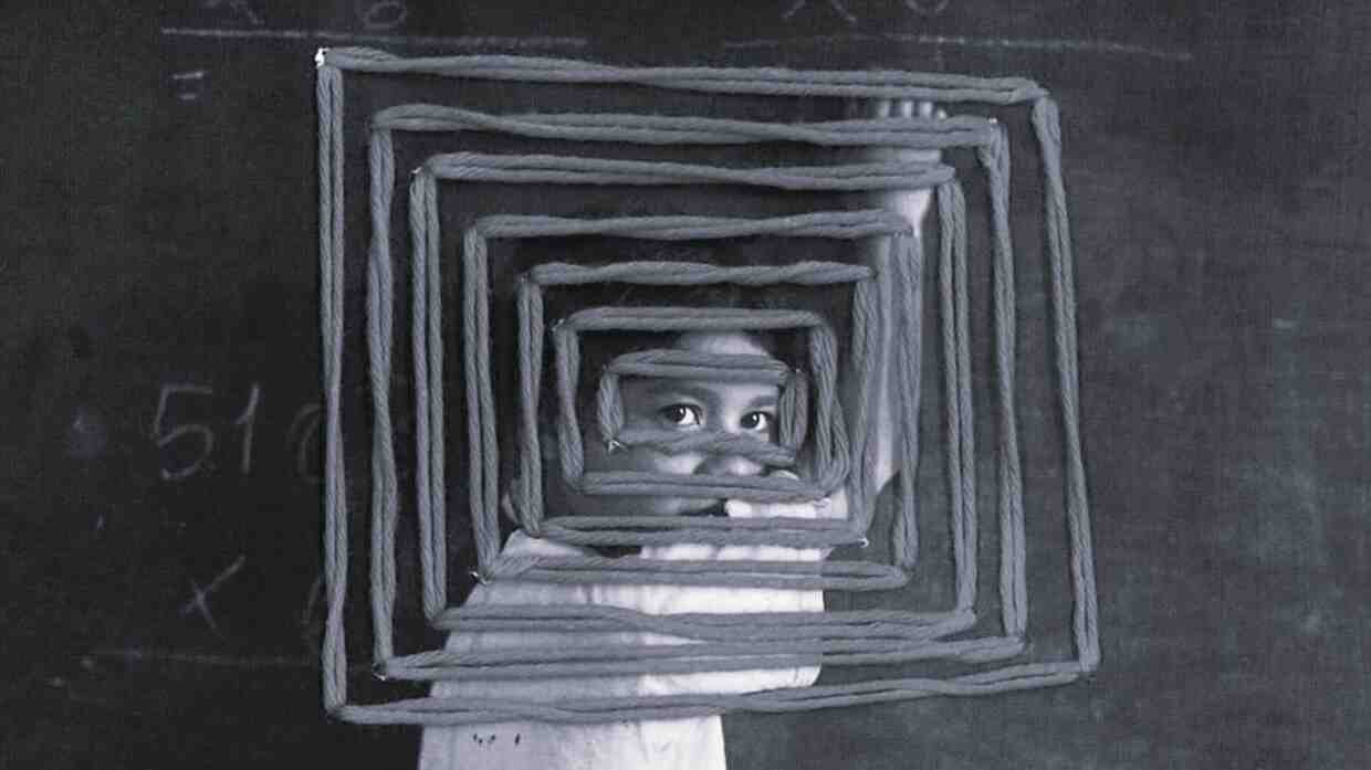 Niña enfocada con fondo de pizarra escolar