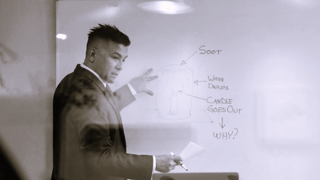 Maestro señalando un diagrama en la pizarra