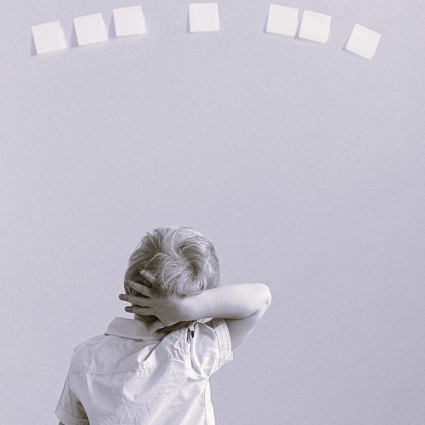 Niño pensando frente a problemas en post-it